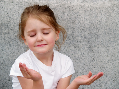 little girl with upturned hands as in prayer or meditation
